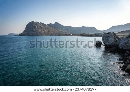 Similar – Image, Stock Photo Distant traveler on rocky formation in sea