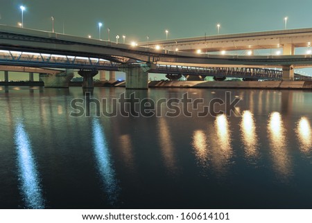 hanged up highways over river waters by night in Tokyo