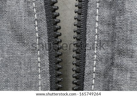 fragment of open plastic zipper fastener of gray cotton jacket