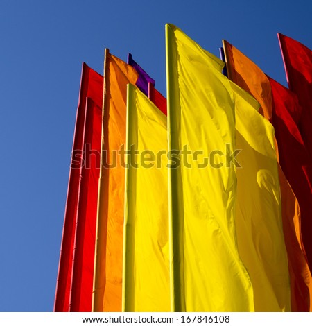 many color flags on the wind with clear blue sky behind
