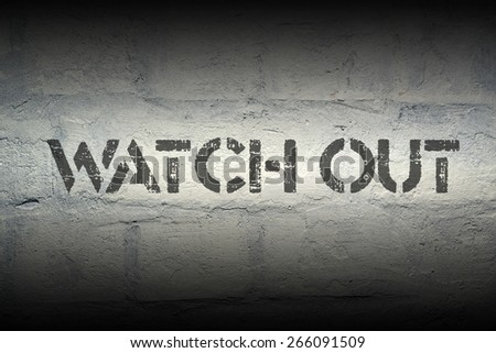 watch out stencil print on the grunge white brick wall