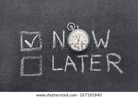 now or later concept handwritten on chalkboard with vintage precise stopwatch used instead of O