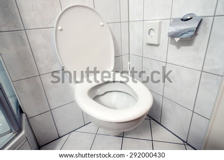 clean toilet room corner with open seat cover