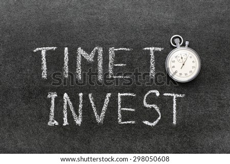 time to invest phrase handwritten on chalkboard with vintage precise stopwatch used instead of O