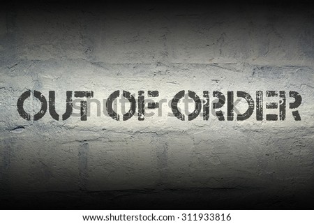 out of order stencil print on the grunge white brick wall