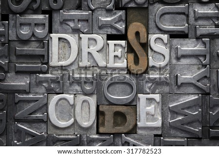 dress code phrase made from metallic letterpress type with letter blocks background