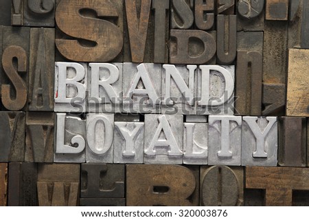 brand loyalty phrase made from metallic letterpress blocks in mixed wooden letters