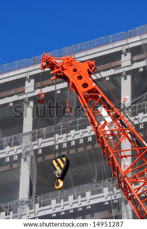 construction site with rising up building and red crane foreground