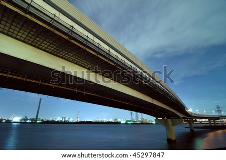huge hanged-up highway going over waters of Arakawa river in Tokyo at windy night weather