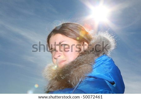 beautiful young woman looks into the distance. against the sun