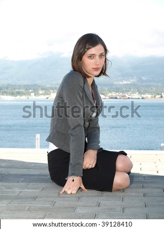 Attractive young professional businesswoman sitting on the floor