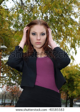 Beautiful young woman in business attire and fall leaves
