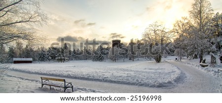 A panorama of a local park in Vasteras, Sweden. Winter with the field covered in snow and the old water tower in the background.