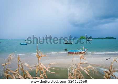 Beach boat fisherman windy , cloudy weather , rain .
