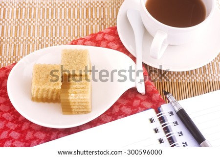 Jelly sweet and tea cup on bamboo mat background, relaxation concept