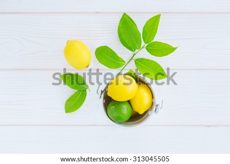 lemon yellow, lime green in a bucket on a light background of boards and leaves