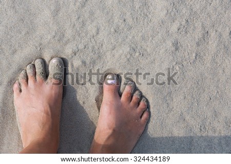 Women's feet in the sand, sand beach of Hendaye, France. summer beach hobby. Fun on the water.