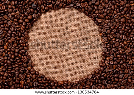 Round frame made of coffee beans on the old burlap