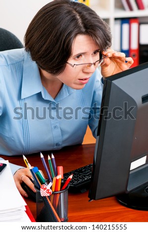 Beautiful business woman thinking while working on computer at her office
