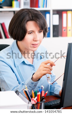 Beautiful business woman thinking while working on computer at her office