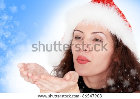 Portrait of christmas girl blows off snowflakes from the hands