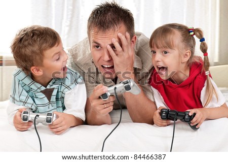 Happy family - father and children playing a video game
