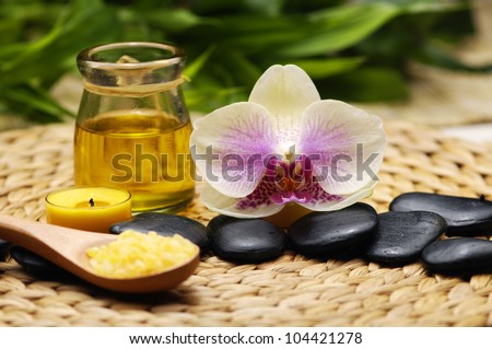 SPA background-candle with white orchid and stones with spa salt in wooden spoon on mat