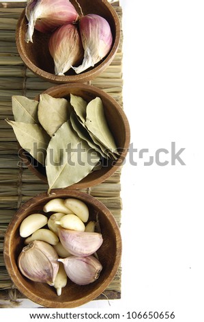 dry bay leaf with garlic and garlic heads in a wooden bowl