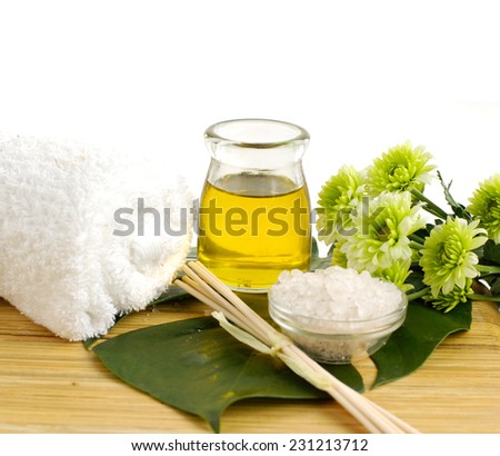 spa concept- bath salt in bowl with green flower and essential oil on board