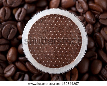 Coffee pods on coffee beans background