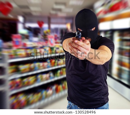 Man in a mask with a gun in the supermarket