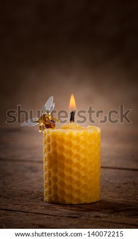 Lighted beeswax candles on wooden table