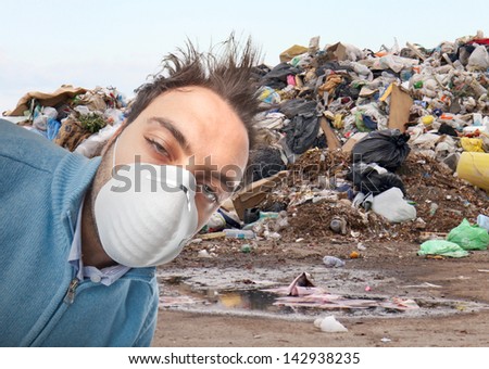 Young boy with mask respiratory protection near landfill