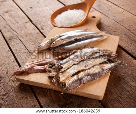 Marinated anchovies with salt on wooden table