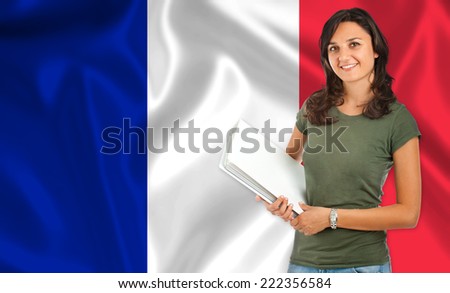 Smiling young female student  over French flag
