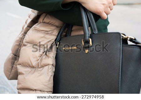 SORRENTO, ITALY - APRIL, 19, 2015: Close up of a Michael Kors bag while a young woman walking in the town center between fashion stores, Sorrento.