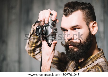 Bearded man shoots with a vintage film camera.