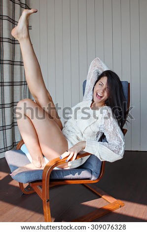 Pretty young woman sitting on a chair and stretching