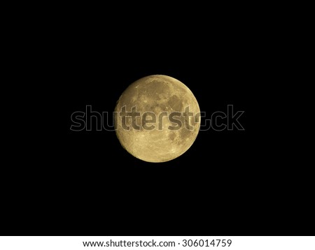Full moon with surface details, seas and craters, in natural yellow color, isolated on black background for design.
