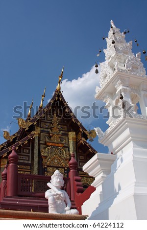 Buddhist temple and carved white tower with wind-bells in Thailand