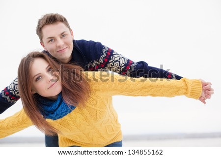 Portrait of happy couple in winter clothes looking at camera
