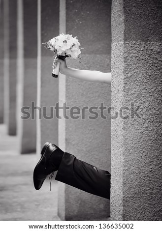 leg of the bride and groom with a bouquet of hand, black and white