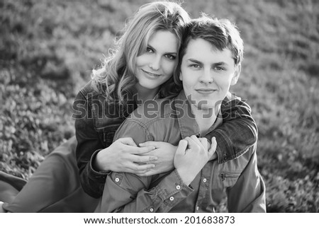 Happy young couple sitting in a park. Black and white photo