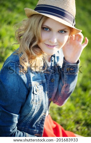 portrait of a beautiful young girl in a straw hat on a background of green grass Stock fotó © 