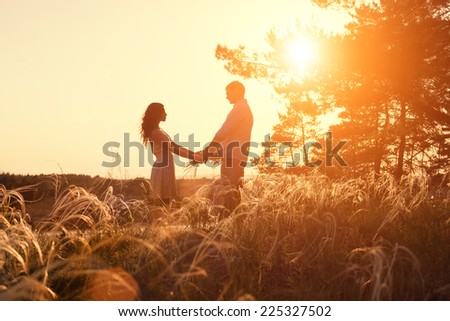 Young couple holding hands at sunrise