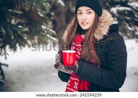 Girl drinking hot tea in the winter forest