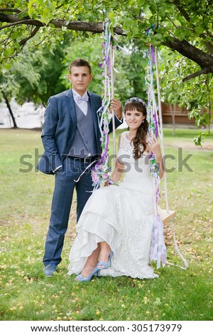 portrait of the bride and groom on a swing