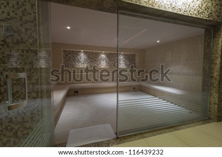 Large steam room with glass door in health spa at a luxury hotel
