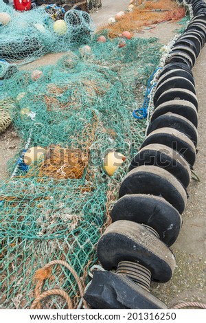 Trawler commercial fishing nets lying on quayside of english harbour