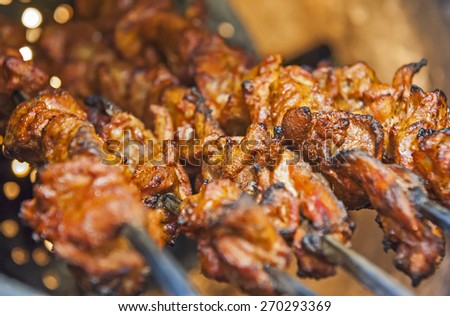 Closeup of chicken tikka kebabs cooking on skewers in indian tandoori oven